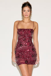Woman wearing a burgundy sequin dress against a white background