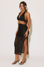 Woman wearing a black dress with mesh panels on a white background