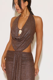 Woman wearing a brown glittery dress against a white background