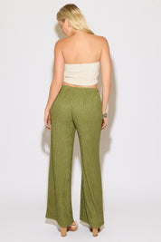 Model is wearing a striped strapless pointed hem bandana top with green flowy pants on a white background.