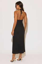 Woman wearing a black halter neck dress on a white background