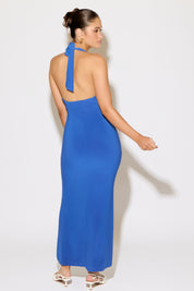 Woman wearing a blue halter neck dress against a white background