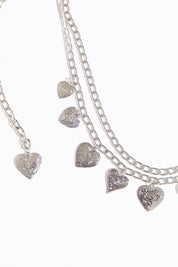 Draped heart charms chain belt on a white background.