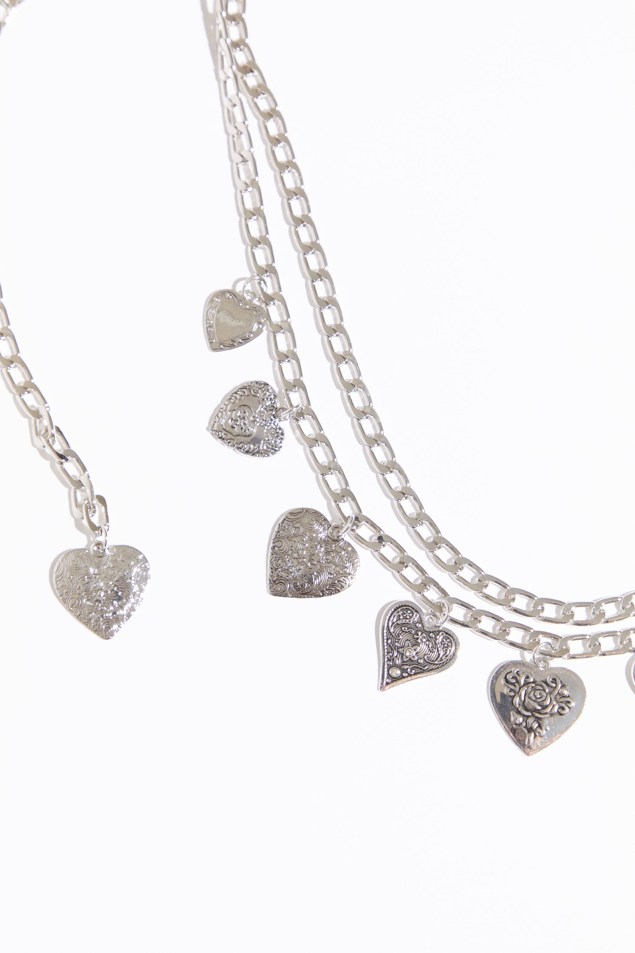 Draped heart charms chain belt on a white background.