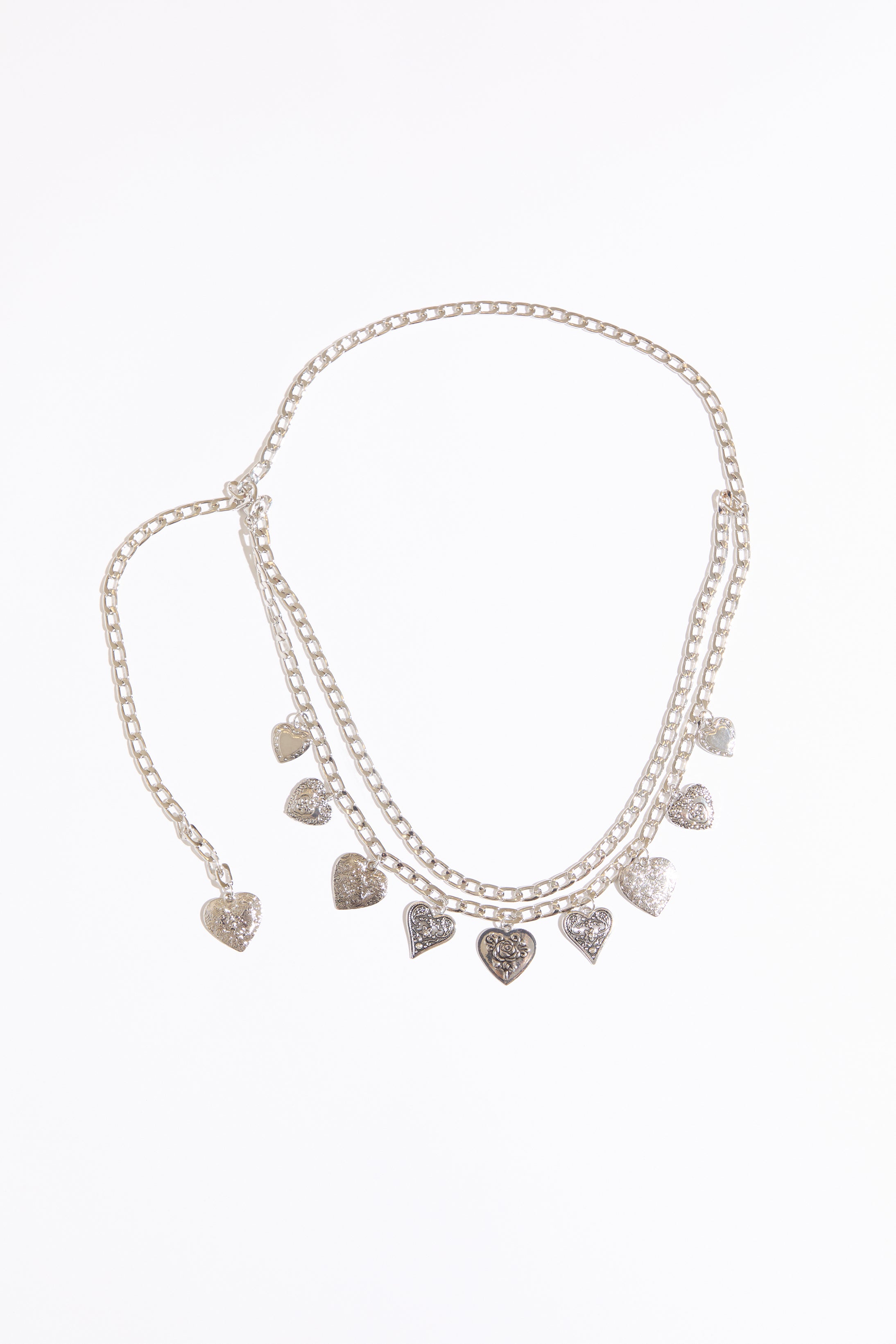Draped heart charms chain belt on a white background.