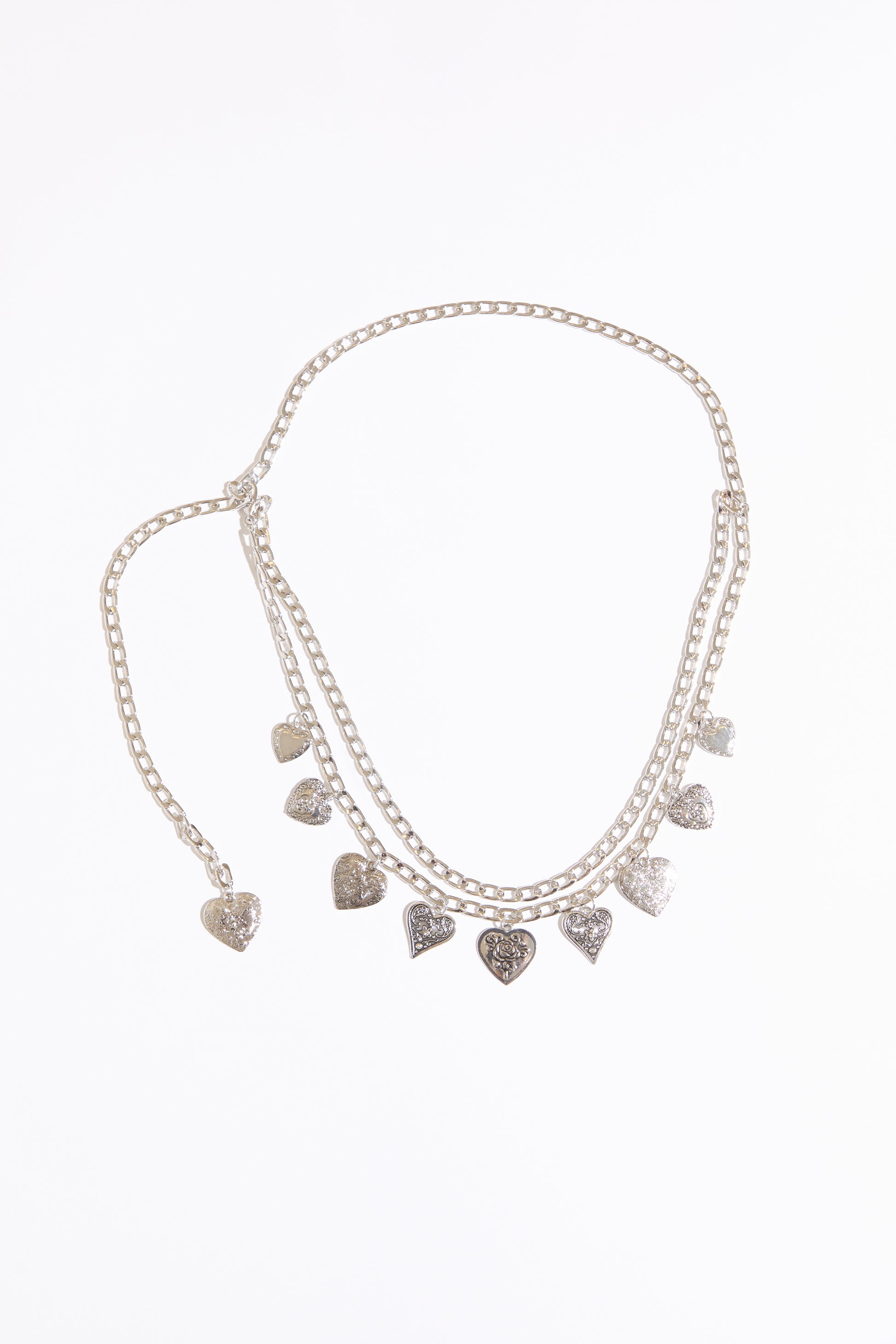 Draped heart charms chain belt on a white background.