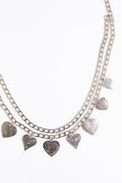 Draped heart charms chain belt on a white background.