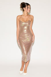 Woman wearing a sparkly gold dress on a white background