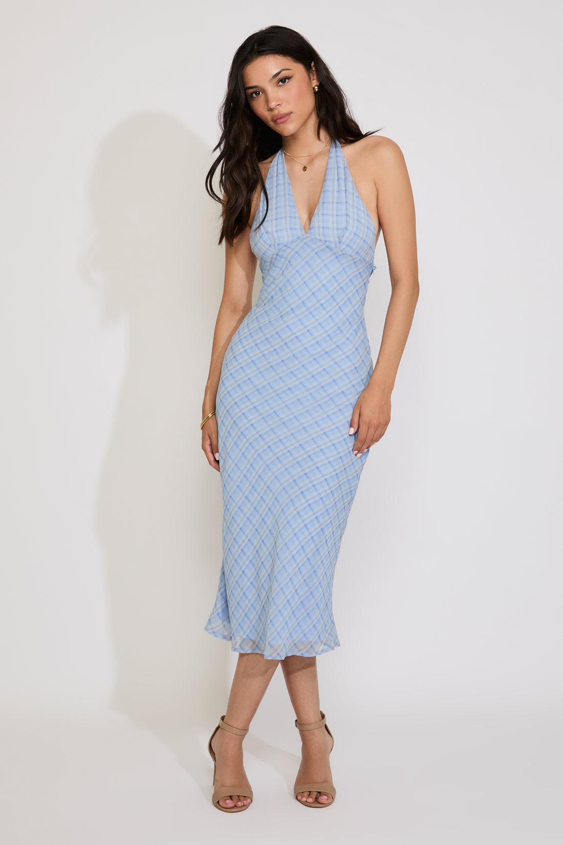 Woman wearing a light blue patterned dress against a white background