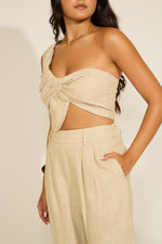 Person wearing a beige strapless top and pants set.
