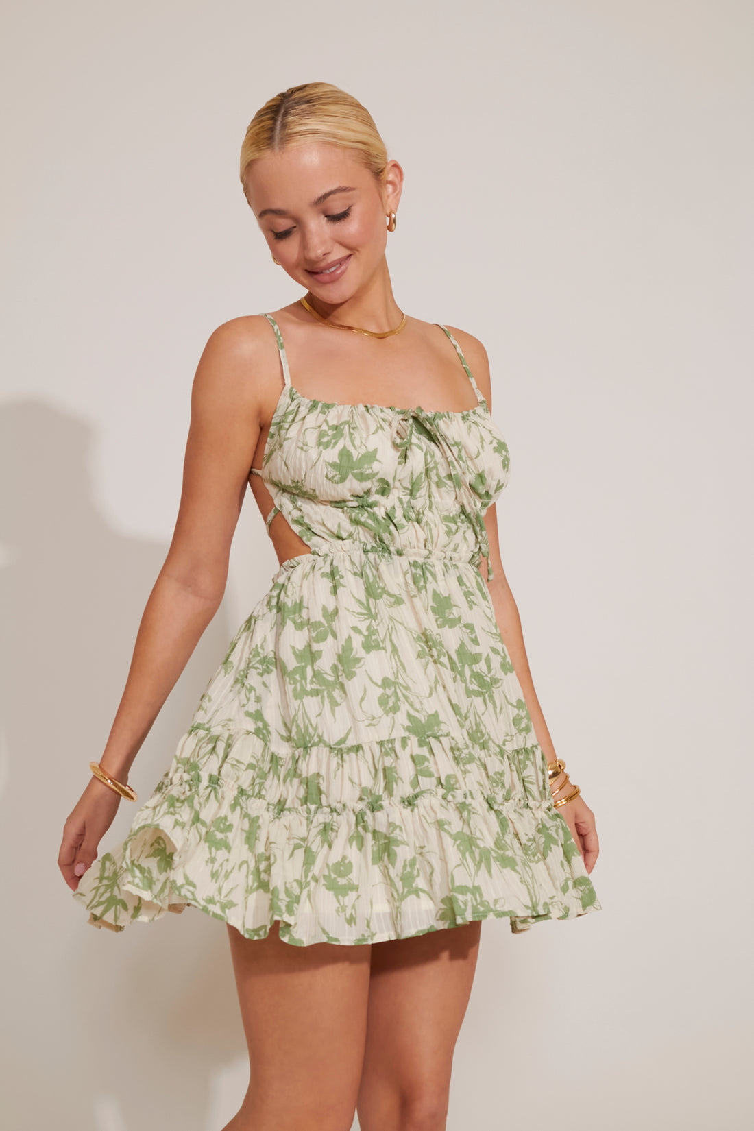 Woman wearing a green floral dress against a plain background