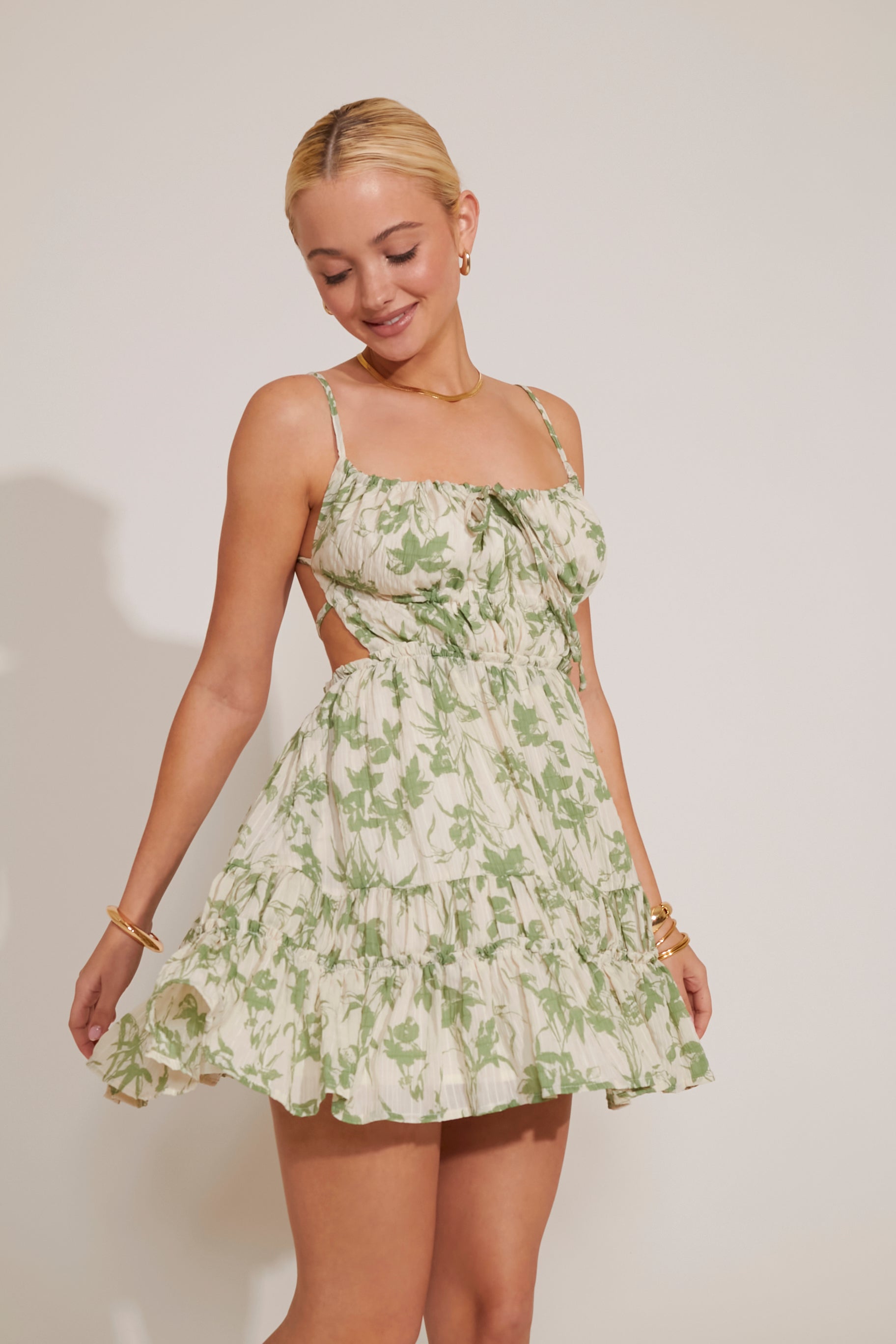 Woman wearing a green floral dress against a plain background