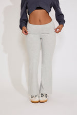 Person wearing gray sweatpants and a dark long-sleeve shirt on a white background