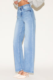 Side view of model wearing light wash denim jeans.