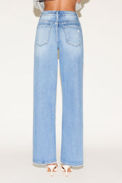 Back view of model wearing light wash denim jeans.