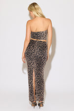 Model is wearing a leopard crop tube top and mesh maxi skirt set on a white background.