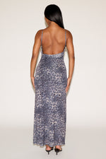 Woman wearing a patterned dress with thin straps on a white background