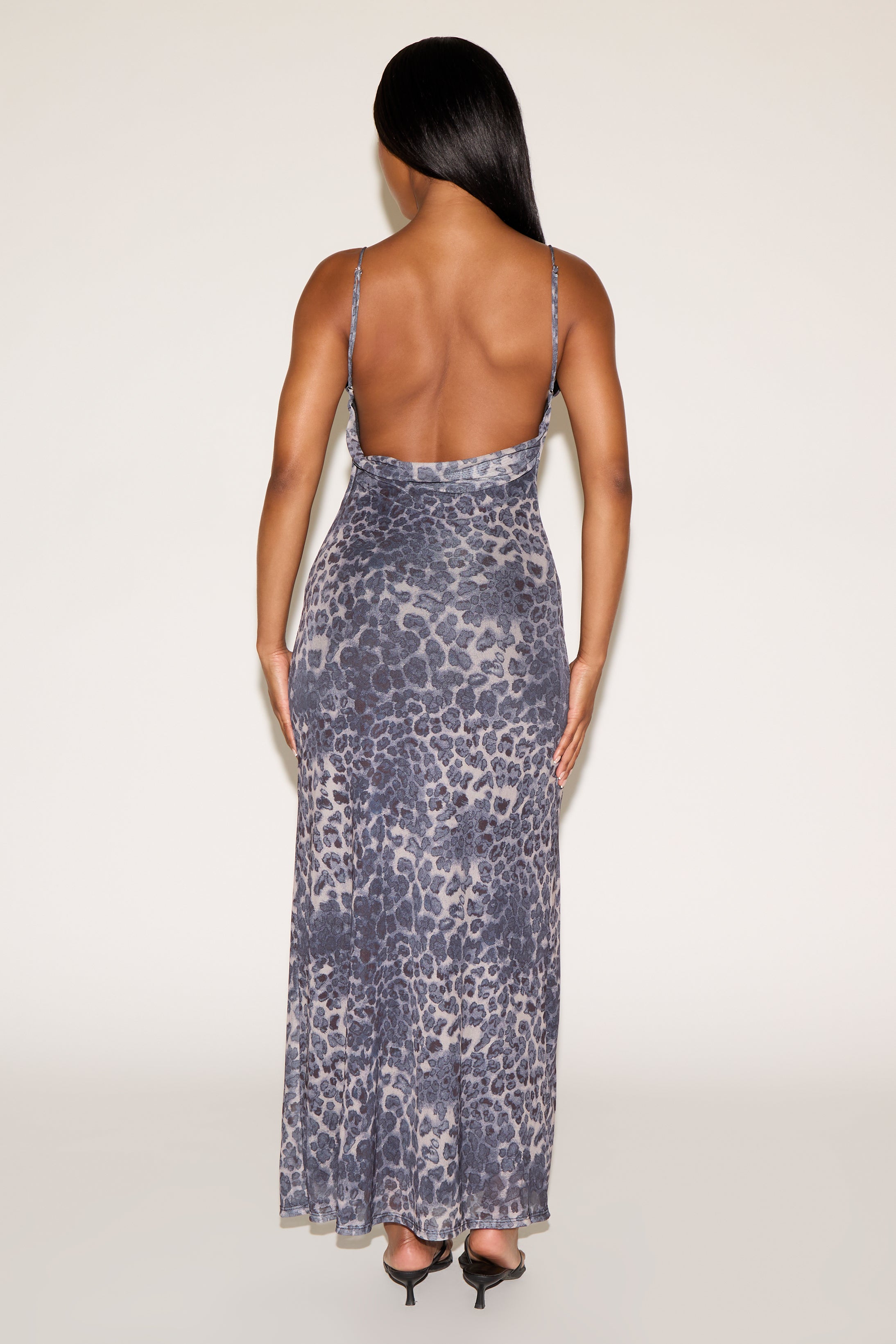 Woman wearing a patterned dress with thin straps on a white background