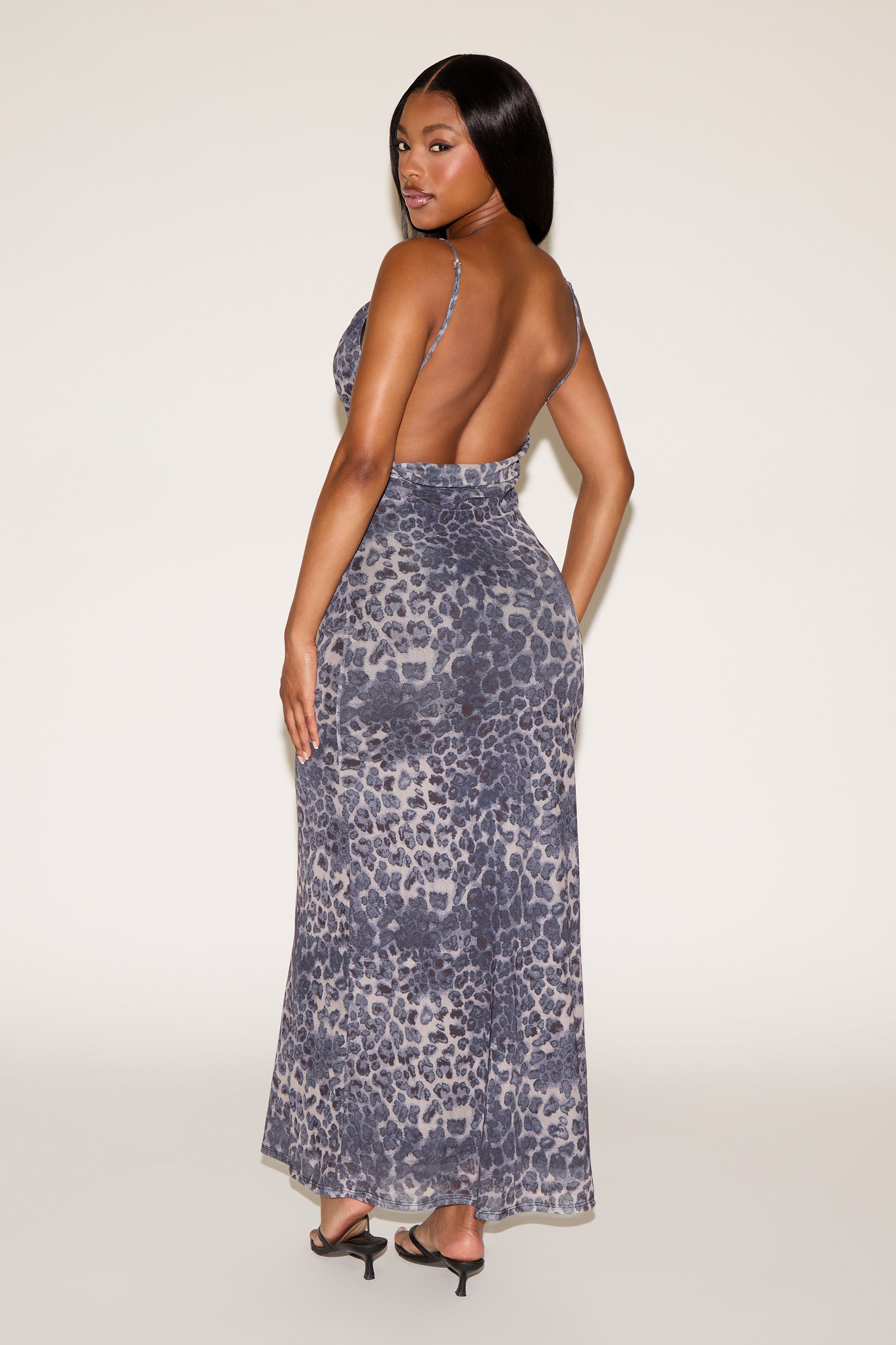 Woman wearing a leopard print dress on a white background
