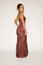 Woman wearing a brown lace evening gown on a white background