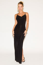 Woman wearing a black slip dress on a white background