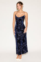 Woman wearing a navy floral dress on a white background