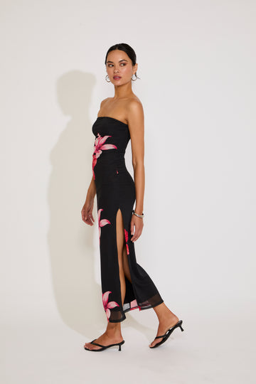 Woman wearing a black strapless dress with floral patterns on a white background