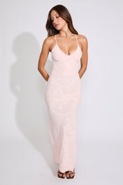 Model is wearing a blush TEXTURED VINE DETAIL CROSS BACK MAXI DRESS with brown heels on a white background.
