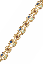Gold bracelet with gemstones on a white background