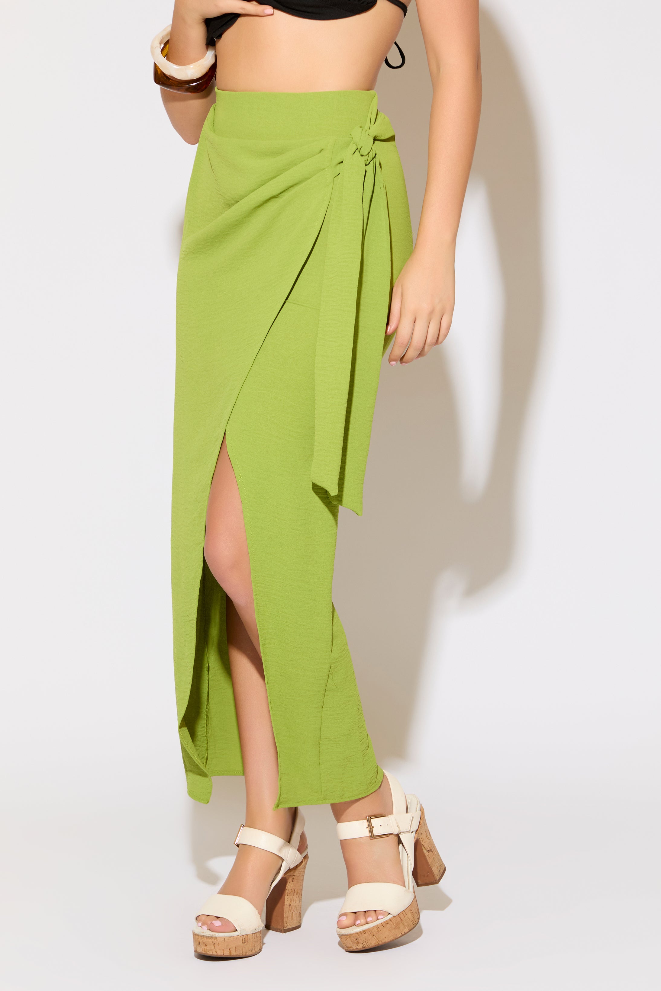 Model is wearing a moss green tie wrap overlay maxi skirt on a white background.