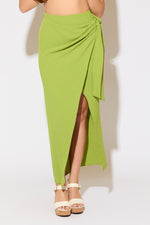 Model is wearing a moss green tie wrap overlay maxi skirt on a white background.