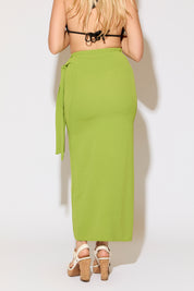 Model is wearing a moss green tie wrap overlay maxi skirt on a white background.
