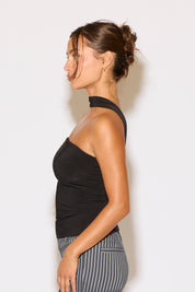 Woman wearing a black halter top and striped pants against a white background