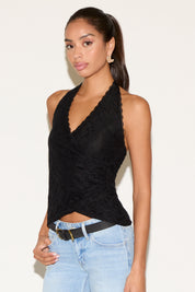 Model wearing a black lace halter top