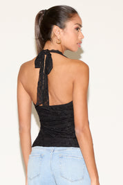 Model wearing a black lace halter top