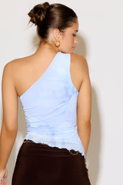 Woman wearing a teal one shoulder top and brown skirt on a white  background