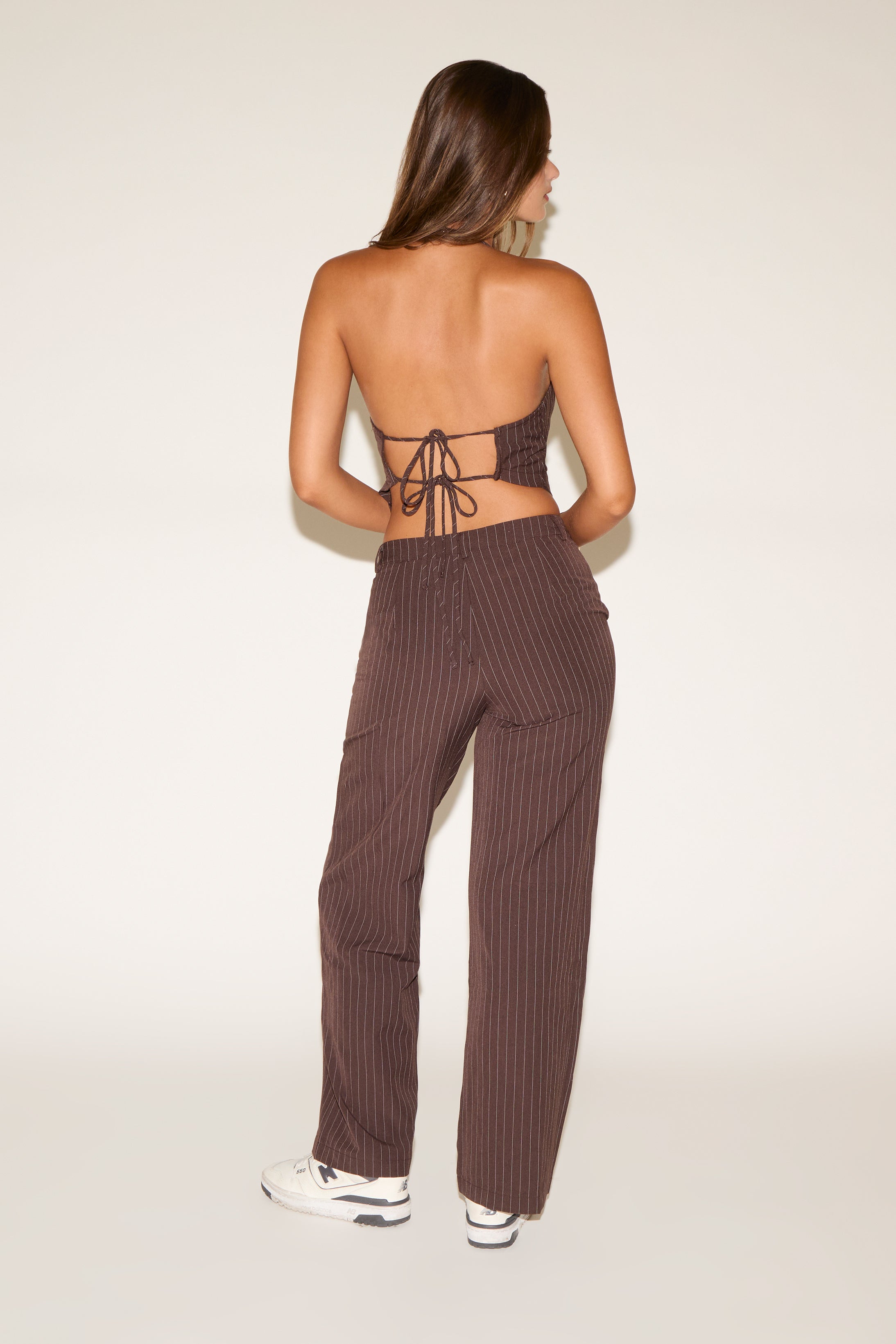 Woman wearing a brown ribbed top and pants set on a white background