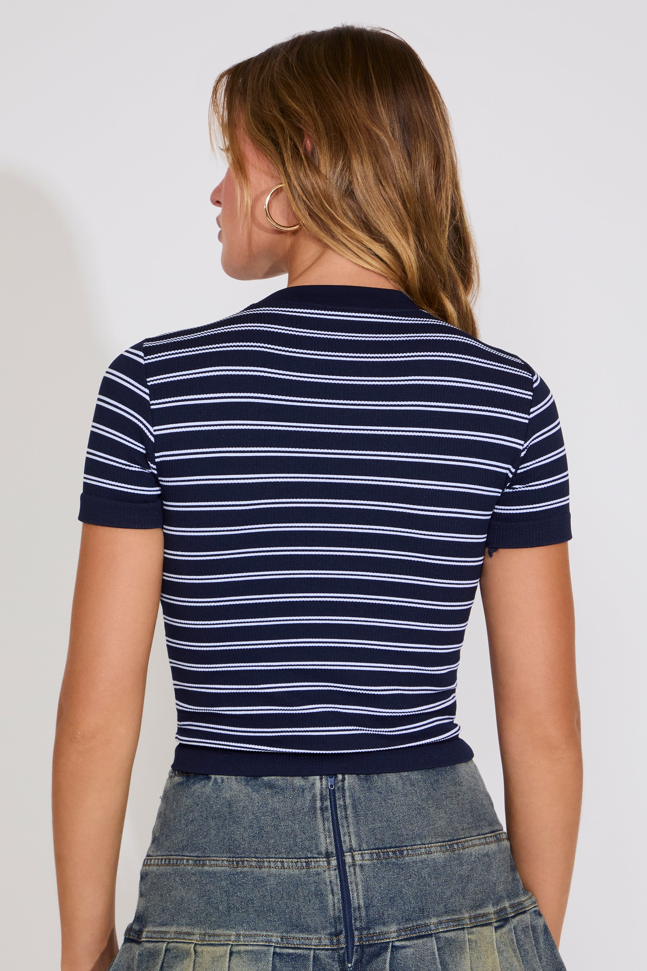 Person wearing a navy and white striped shirt with a plain background