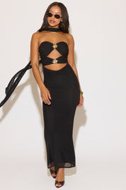 Woman wearing a black dress with cut-out design on a white background