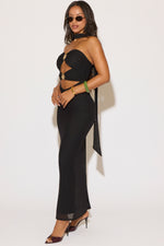 Woman wearing a black dress with sheer panels on a white background