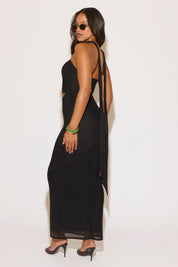 Woman wearing a black dress with cut-out sides against a white background