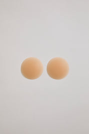 Two beige circular pastries on a light gray background