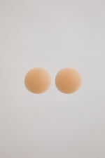 Two beige circular pastries on a light gray background