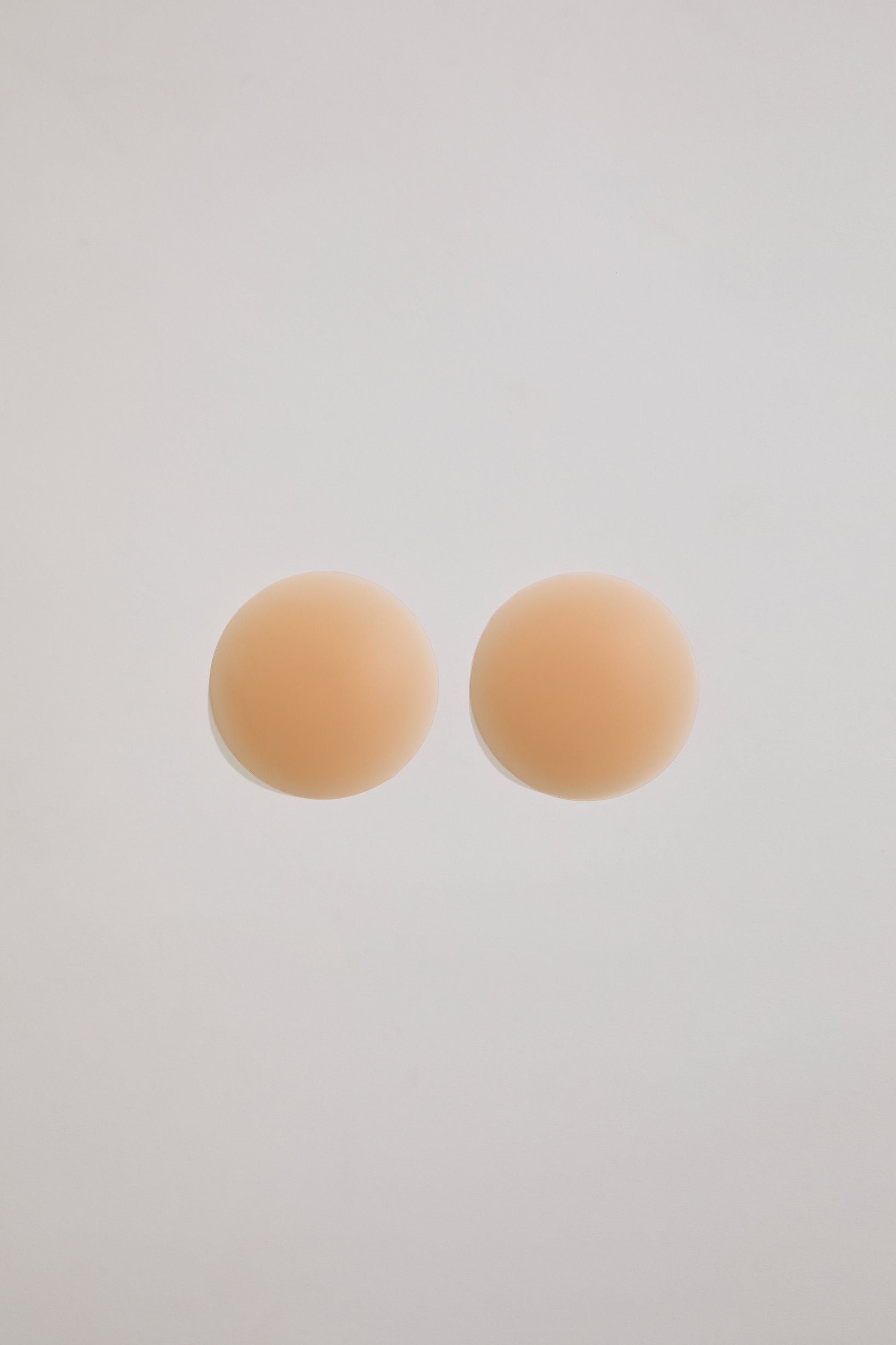 Two beige circular pastries on a light gray background