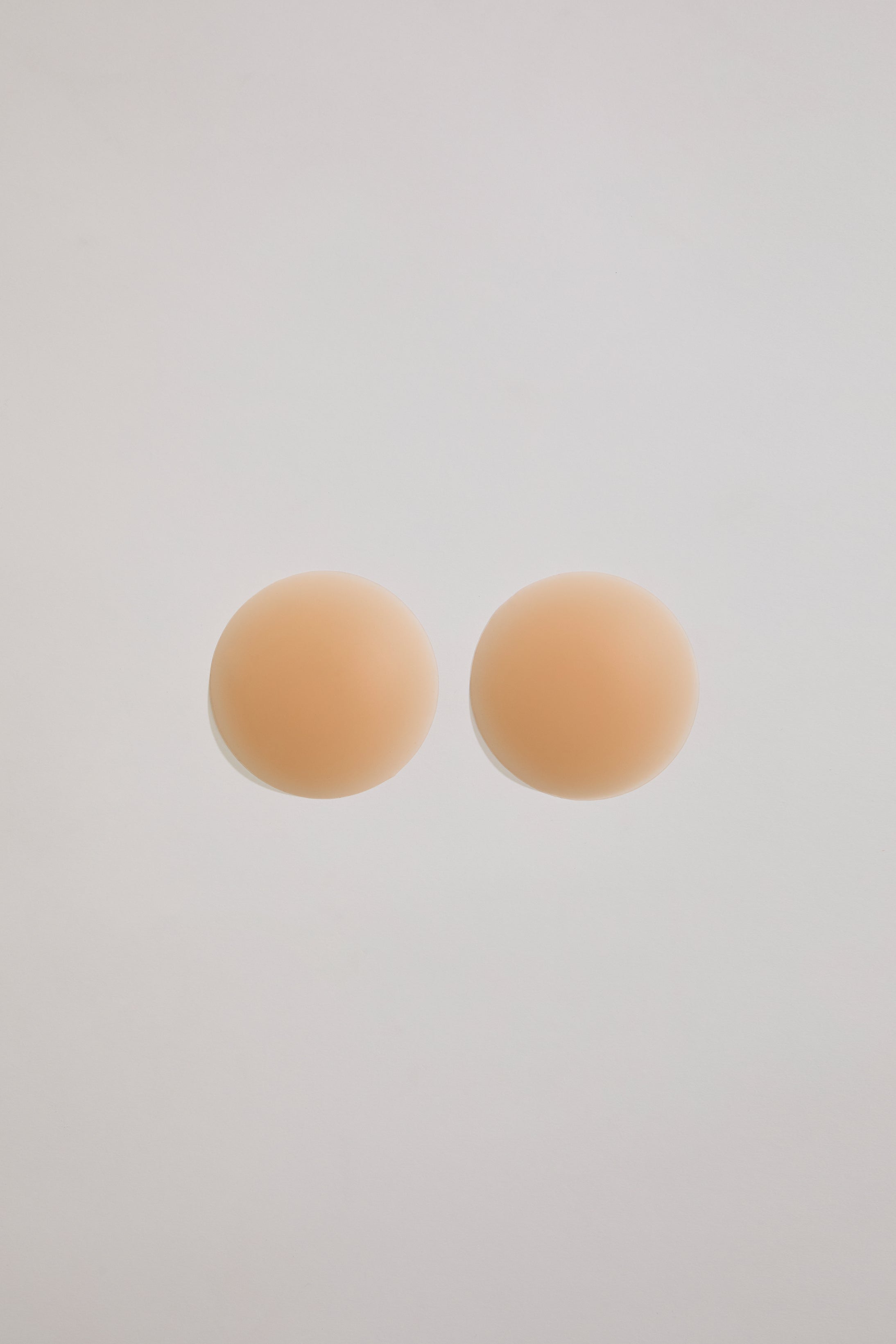 Two beige circular pastries on a light gray background