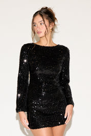 Woman wearing a black sequin dress against a white background