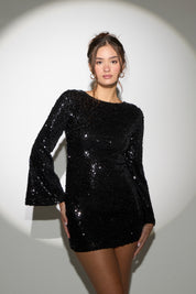 Woman wearing a black sequin dress against a white background