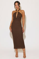 Woman wearing a brown halter neck dress against a white background