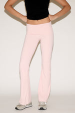 Person wearing pink pants and a black top on a white background
