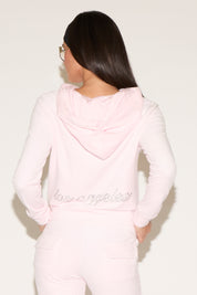 Person wearing a pink hoodie with 'love everything' text on the back against a white background